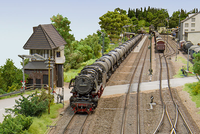 Überblick über den Bad Driburger Bahnhof. Am Stellwerk Do rauscht ein Kesselwagenzug zu Tal. Der in Gleis 3 zur Seite genommene Güterzug lässt vermuten, dass gleich in Gleis 2 ein Reisezug einfährt. Foto: Gerard Tombroek