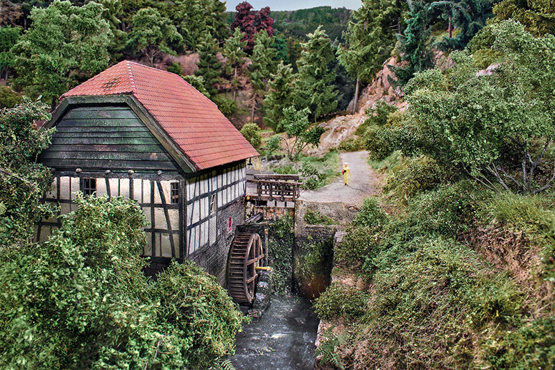 Diese in Fachwerkbauweise und mit einem Krüppelwalmdach errichtete Wassermühle Heller hat ihren Originalstandplatz im Freilichtmuseum Detmold. Bei der Modellbundesbahn rauscht der Mühlbach am Klapperweg. Abgebildet ist natürlich das Modell - natürlich? Foto: Markus Tiedtke